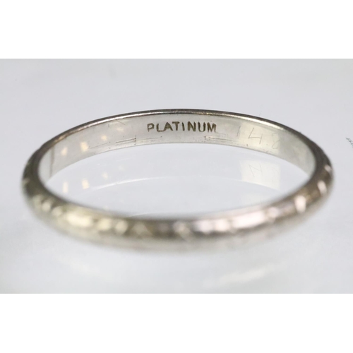 202 - Platinum wedding band ring with incised detailing (marked platinum, size O.5) together with a white ... 