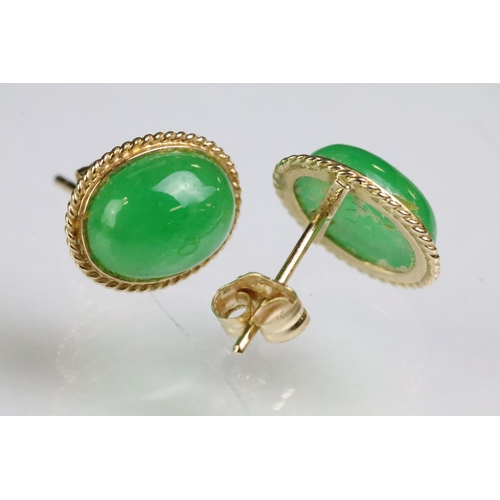 204 - Pair of 14ct gold and jade stud earrings. The earrings being set with oval jade cabochons. Marked 14... 