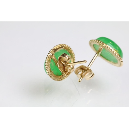 204 - Pair of 14ct gold and jade stud earrings. The earrings being set with oval jade cabochons. Marked 14... 