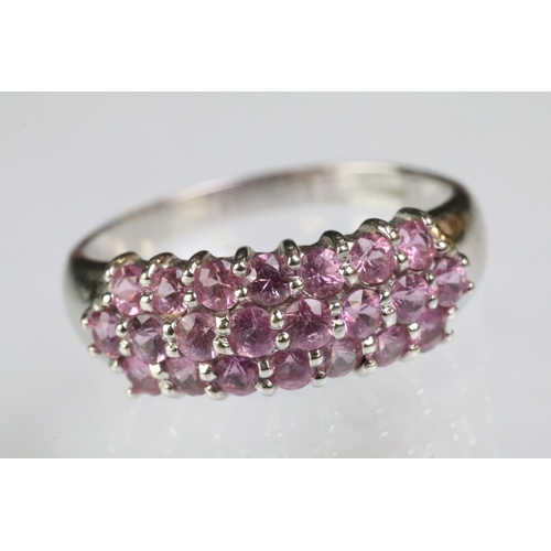 211 - 9ct white gold hallmarked dome ring set with three rows of round cut pink stones. Hallmarked London.... 