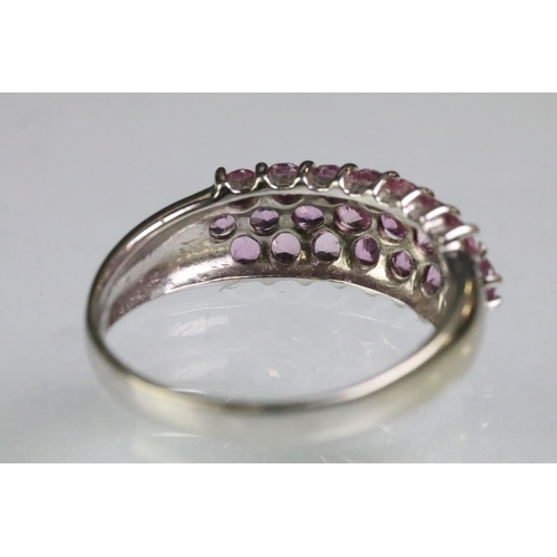 211 - 9ct white gold hallmarked dome ring set with three rows of round cut pink stones. Hallmarked London.... 