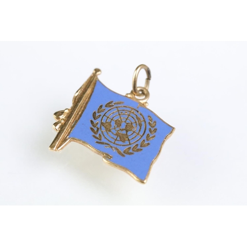 215 - Collection of gold charms to include a 9ct gold hallmarked cross, 14ct gold enamelled flag charm (ma... 