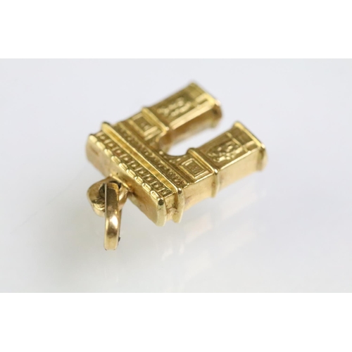 215 - Collection of gold charms to include a 9ct gold hallmarked cross, 14ct gold enamelled flag charm (ma... 