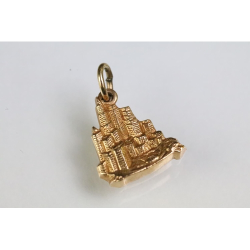 215 - Collection of gold charms to include a 9ct gold hallmarked cross, 14ct gold enamelled flag charm (ma... 