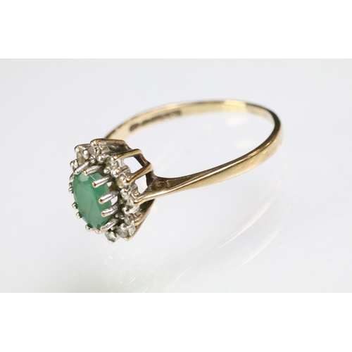 216 - 9ct gold hallmarked emerald and diamond cluster ring. The ring being set with an oval cut emerald su... 