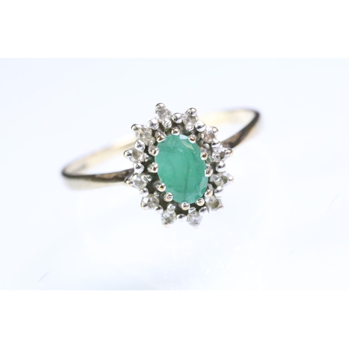 216 - 9ct gold hallmarked emerald and diamond cluster ring. The ring being set with an oval cut emerald su... 