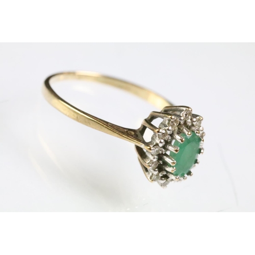 216 - 9ct gold hallmarked emerald and diamond cluster ring. The ring being set with an oval cut emerald su... 