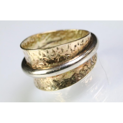 224 - 9ct gold two tone ring having a wide textured band with white gold ring to centre. Marked 375. Size ... 