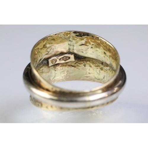 224 - 9ct gold two tone ring having a wide textured band with white gold ring to centre. Marked 375. Size ... 