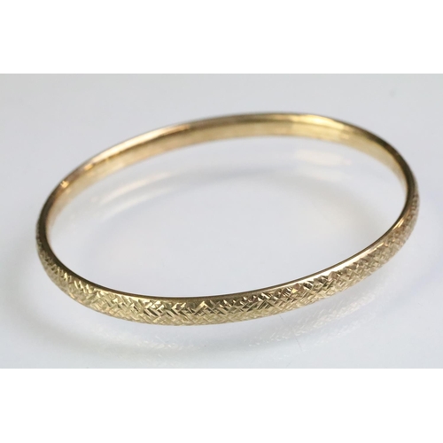 228 - 9ct gold hallmarked bangle bracelet having a textured exterior. Import marked 1990. Interior width 6... 