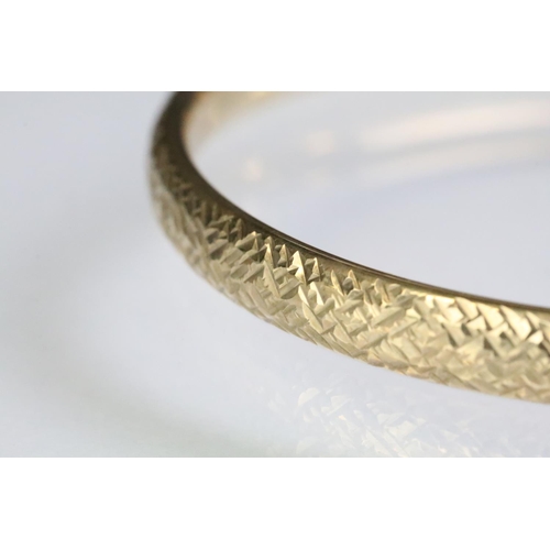 228 - 9ct gold hallmarked bangle bracelet having a textured exterior. Import marked 1990. Interior width 6... 