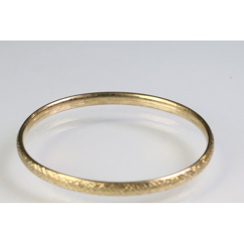 228 - 9ct gold hallmarked bangle bracelet having a textured exterior. Import marked 1990. Interior width 6... 