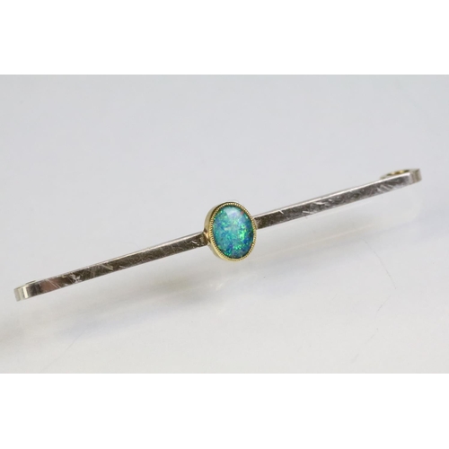 238 - 15ct gold and opal bar brooch having a bezel set oval opal cabochon to centre showing green and blue... 