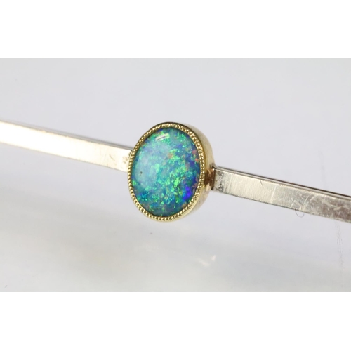 238 - 15ct gold and opal bar brooch having a bezel set oval opal cabochon to centre showing green and blue... 