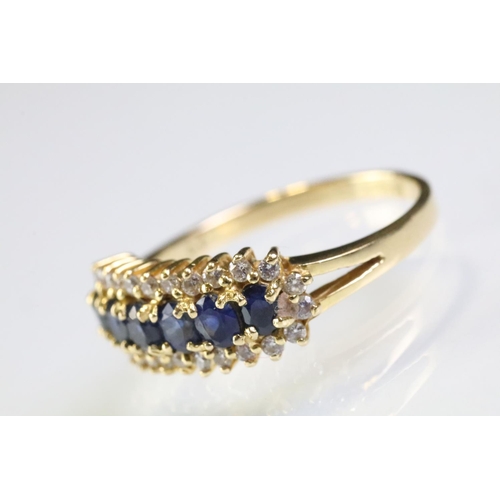 260 - 18ct gold sapphire and diamond line ring. The ring being set with six oval cut sapphires surrounded ... 