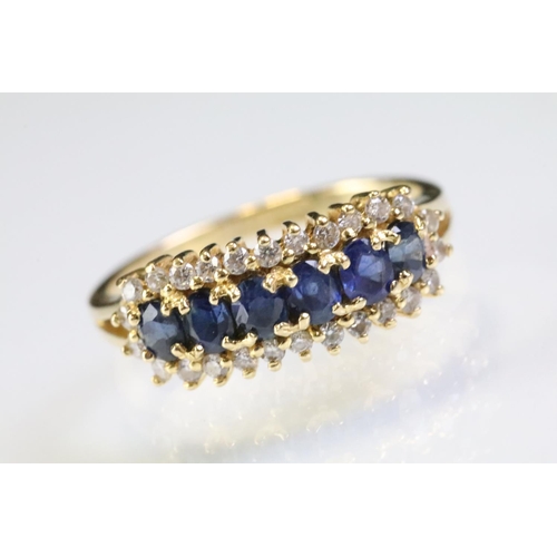 260 - 18ct gold sapphire and diamond line ring. The ring being set with six oval cut sapphires surrounded ... 