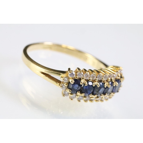 260 - 18ct gold sapphire and diamond line ring. The ring being set with six oval cut sapphires surrounded ... 