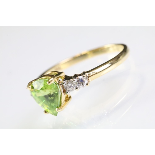 296 - 18ct gold sphene and diamond ring. The ring being set with a pear cut peridot to centre flanked by t... 