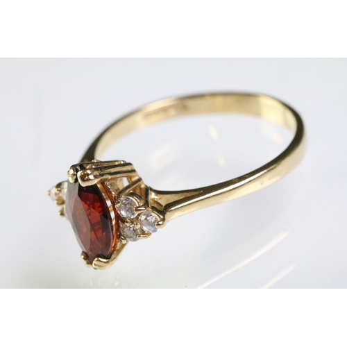 298 - 9ct gold garnet and white stone ring being set with a marquise cut garnet to centre with three white... 