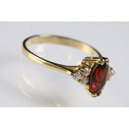 298 - 9ct gold garnet and white stone ring being set with a marquise cut garnet to centre with three white... 