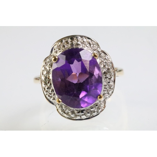 299 - 9ct gold and amethyst dress ring being set with a large oval cut amethyst to the centre with diamond... 