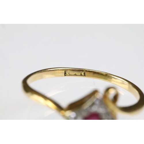 307 - 18ct gold ruby and diamond panel ring having a round cut ruby to centre surrounded by four diamond c... 