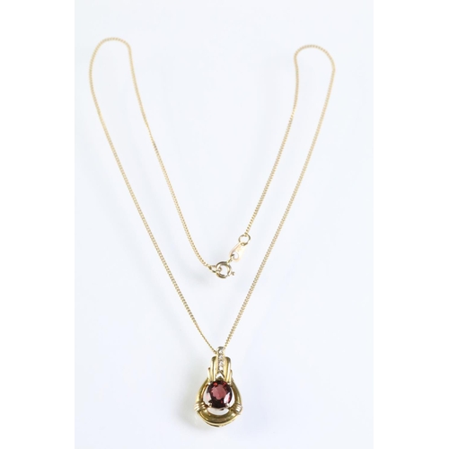 309 - 9ct gold and ruby pendant being set with an oval cut ruby within a gold mount with accent stones to ... 