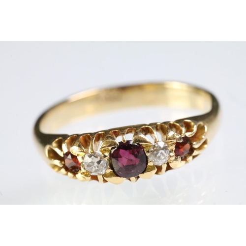 311 - 9ct gold garnet and diamond five stone ring. The ring being set with three round cut garnets with tw... 