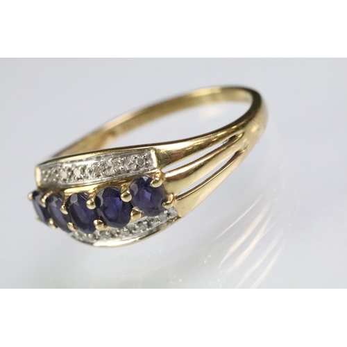 62 - Hallmarked 9ct gold purple stone and diamond ring. The ring being set with five oval cut purple ston... 