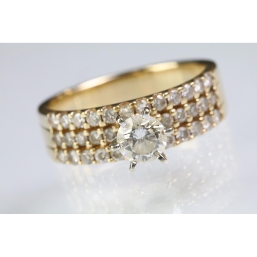 74 - 14ct gold and diamond ring. The ring being prong set with a round brilliant cut diamond with three r... 