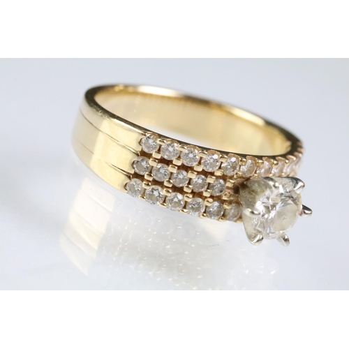 74 - 14ct gold and diamond ring. The ring being prong set with a round brilliant cut diamond with three r... 