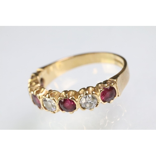 90 - 18ct gold, ruby and diamond seven stone ring. The ring being set with three round cut diamonds, and ... 