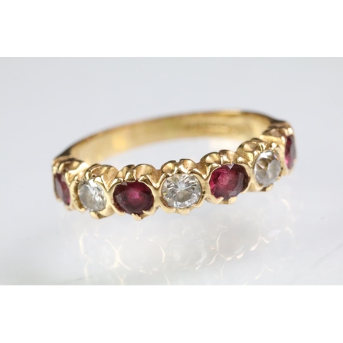 90 - 18ct gold, ruby and diamond seven stone ring. The ring being set with three round cut diamonds, and ... 