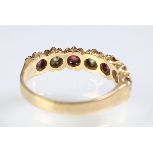 90 - 18ct gold, ruby and diamond seven stone ring. The ring being set with three round cut diamonds, and ... 