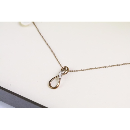 93 - 9ct gold and diamond pendant necklace. The necklace having a fine link chain with figure of eight in... 