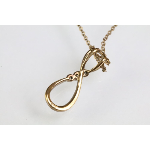 93 - 9ct gold and diamond pendant necklace. The necklace having a fine link chain with figure of eight in... 