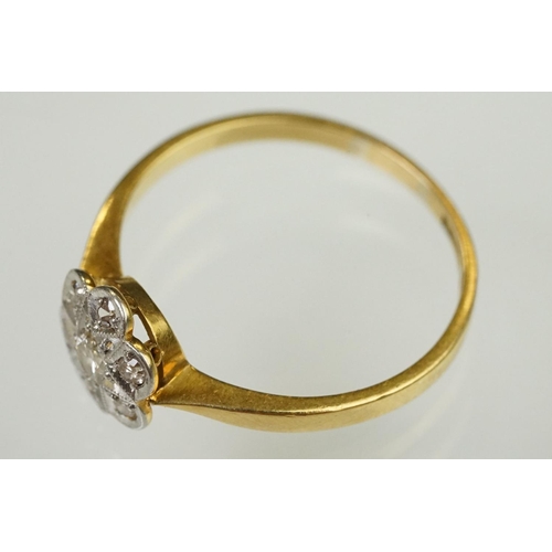 101 - 1920s 18ct gold, platinum and diamond daisy head ring being set with seven round cut diamonds on tap... 