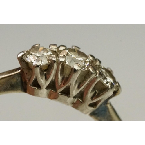 105 - Three stone diamond ring being set with three round brilliant cut diamonds in prong settings with wh... 