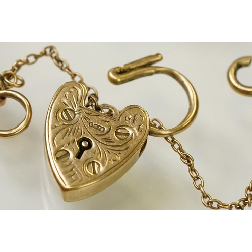 123 - 9ct gold heart padlock mounted to a curb link rose metal bracelet. Bracelet hallmarked London 1957. ... 