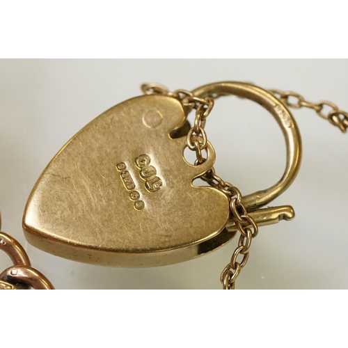 123 - 9ct gold heart padlock mounted to a curb link rose metal bracelet. Bracelet hallmarked London 1957. ... 