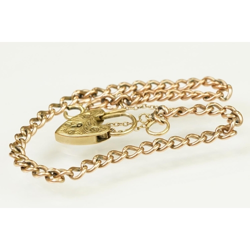 123 - 9ct gold heart padlock mounted to a curb link rose metal bracelet. Bracelet hallmarked London 1957. ... 