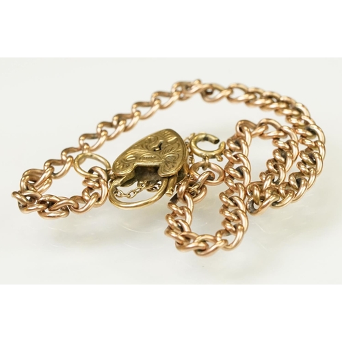 123 - 9ct gold heart padlock mounted to a curb link rose metal bracelet. Bracelet hallmarked London 1957. ... 