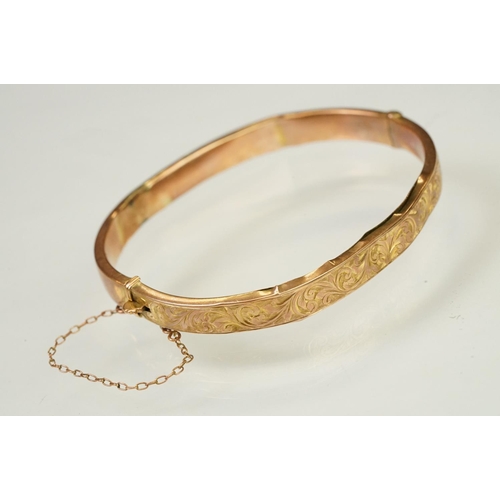 124 - 9ct gold hallmarked hinged bangle bracelet. The bracelet having incised scrolled foliate detailing, ... 