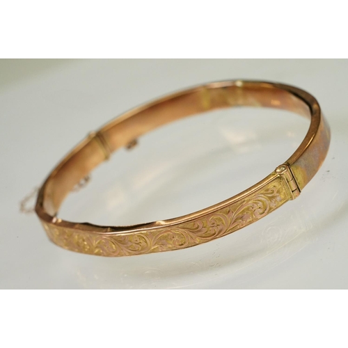 124 - 9ct gold hallmarked hinged bangle bracelet. The bracelet having incised scrolled foliate detailing, ... 