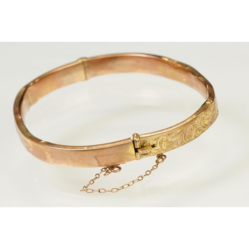 124 - 9ct gold hallmarked hinged bangle bracelet. The bracelet having incised scrolled foliate detailing, ... 