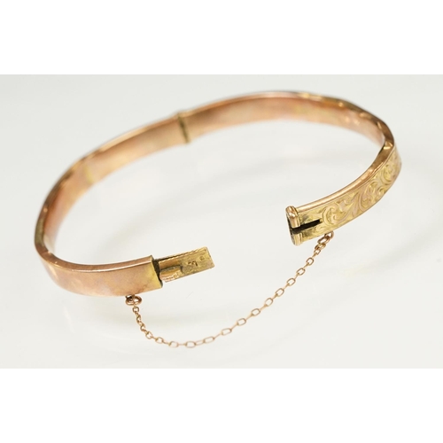 124 - 9ct gold hallmarked hinged bangle bracelet. The bracelet having incised scrolled foliate detailing, ... 