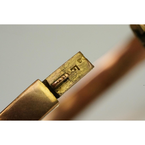 124 - 9ct gold hallmarked hinged bangle bracelet. The bracelet having incised scrolled foliate detailing, ... 