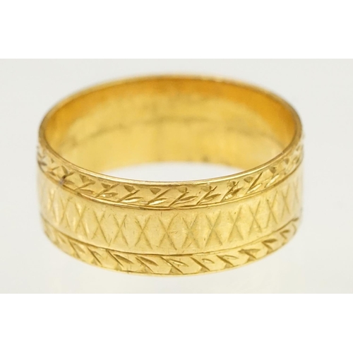 130 - 22ct hallmarked gold band ring. The wide band having incised detailing. Hallmarked London 1961, size... 