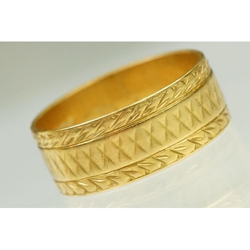 130 - 22ct hallmarked gold band ring. The wide band having incised detailing. Hallmarked London 1961, size... 