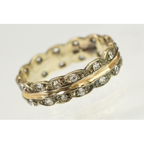 132 - 9ct gold hallmarked two tone eternity ring. The ring having a faceted rose gold centre with scallope... 